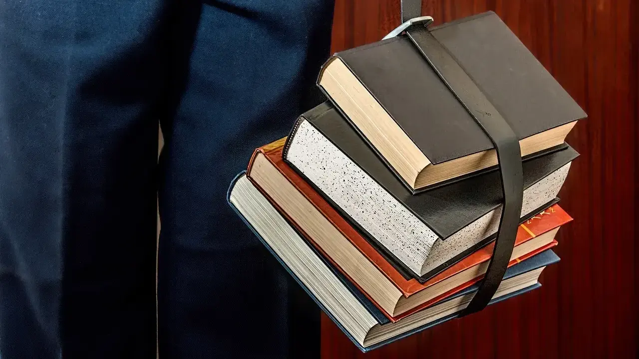 Stos książek, symbol wiedzy, idealny na studia dietetyka Łódź.