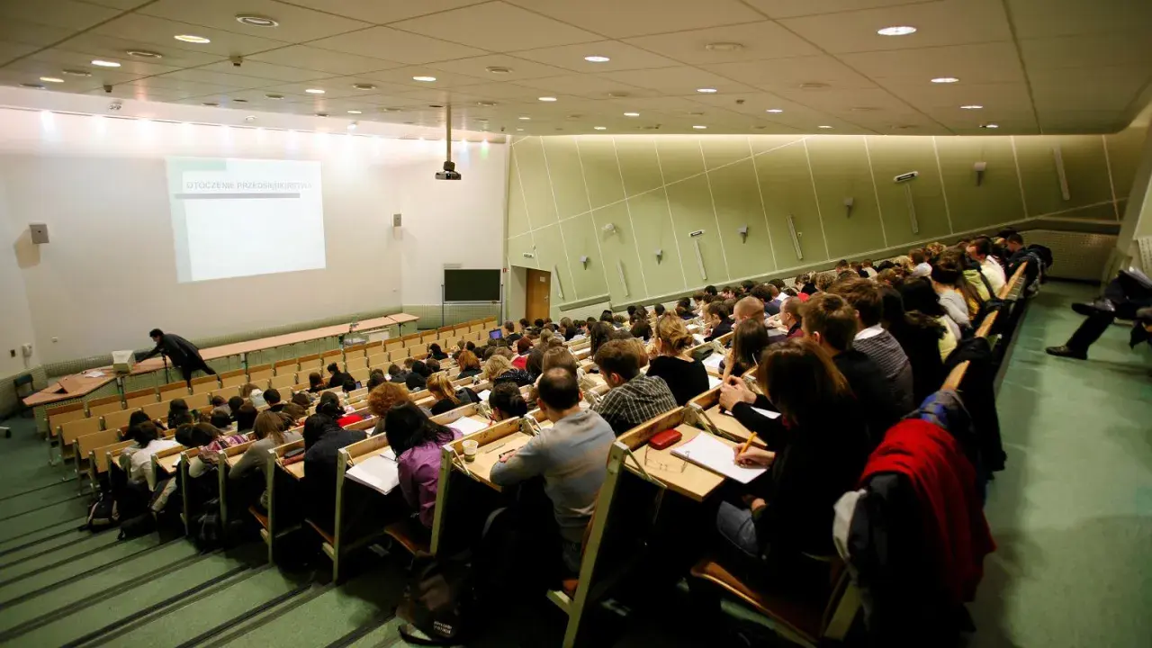 Wykład w auli uniwersyteckiej. Studenci siedzą w rzędach, słuchając wykładowcy. Może to być jeden z najmniej obleganych kierunków studiów, skoro sala jest tak pusta.
