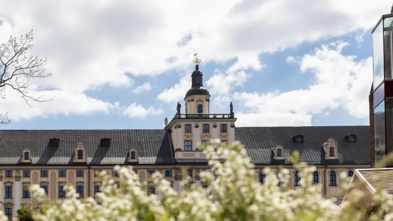Majestatyczny gmach, idealne miejsce na studia we Wrocławiu. Wiosna kwitnie, a chmury na niebie zapraszają do nauki.