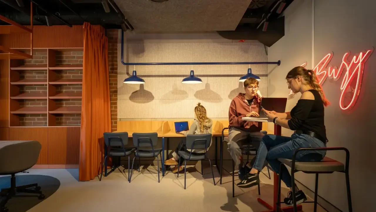 Studenci szukają inspiracji, jak załatwić praktyki studenckie, w nowoczesnym, "busy" wnętrzu.