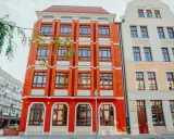 Jasna fasada i ceglany budynek przyciągają wzrok. Może tu mieści się filologia angielska we Wrocławiu?