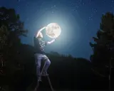 Mężczyzna na drabinie trzyma księżyc, marząc o studiach z astronomii. Nocne niebo pełne gwiazd.