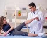 Fizjoterapeuta bada nogę pacjentki. Dowiedz się, jak zostać fizjoterapeutą i pomagać w powrocie do zdrowia.
