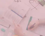 Uczniowie studiują, a na biurku leżą książki, okulary i kalkulator. Czy oceny na studiach mają znaczenie?