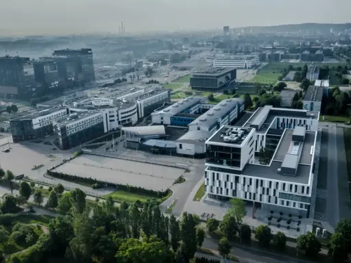 Nowoczesne budynki ULO Gdańsk w otoczeniu zieleni i infrastruktury miejskiej.