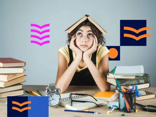 Zmęczona studentka z książką na głowie, otoczona stosami książek i materiałami do nauki. Tak wyglądają studia niestacjonarne.