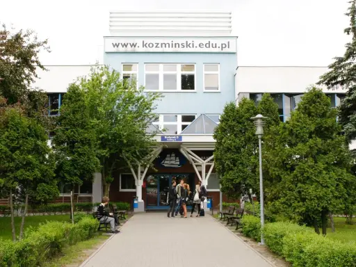 Studenci przed budynkiem koźmin uczelnia. W tle logo uczelni i napis www.kozminiński.edu.pl.