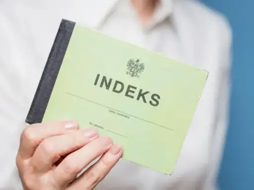 Zielony indeks, symbol studiów magisterskich w Łodzi, w dłoni studenta.