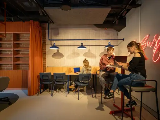 Studenci szukają inspiracji, jak załatwić praktyki studenckie, w nowoczesnym, "busy" wnętrzu.