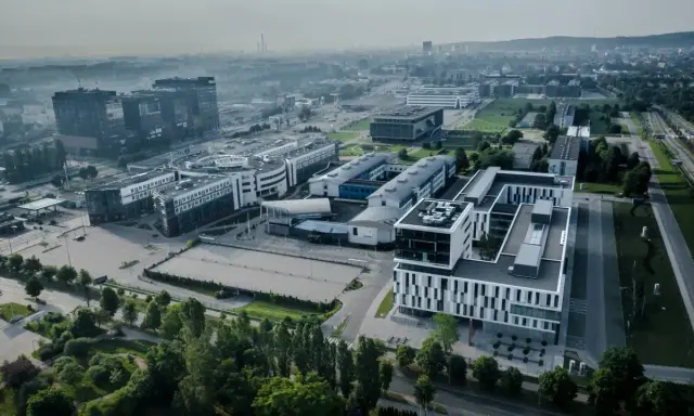 Nowoczesne budynki ULO Gdańsk w otoczeniu zieleni i infrastruktury miejskiej.