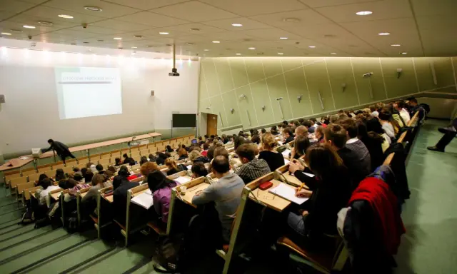 Wykład w auli uniwersyteckiej. Studenci siedzą w rzędach, słuchając wykładowcy. Może to być jeden z najmniej obleganych kierunków studiów, skoro sala jest tak pusta.