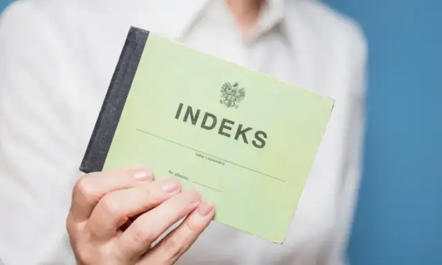 Zielony indeks, symbol studiów magisterskich w Łodzi, w dłoni studenta.
