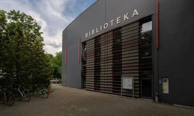 Nowoczesna biblioteka na terenie Akademii Ignatianum w Krakowie. Obok stoją rowery.
