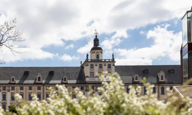 Majestatyczny gmach, idealne miejsce na studia we Wrocławiu. Wiosna kwitnie, a chmury na niebie zapraszają do nauki.