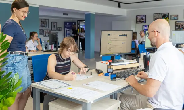 Studentka wypełnia dokumenty w biurze Zachodniopomorskiego Uniwersytetu Technologicznego w Szczecinie.
