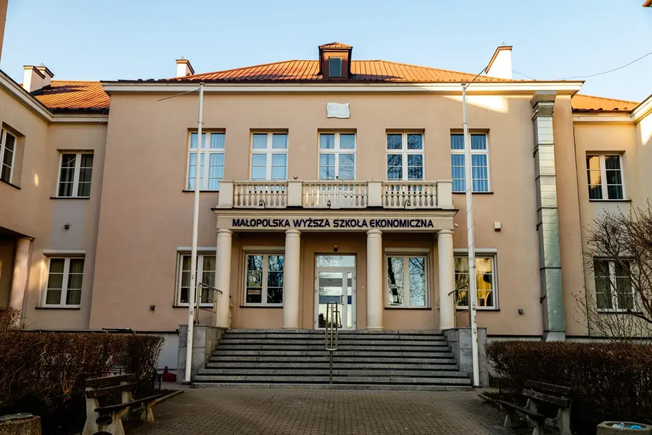 Elegancki budynek Małopolskiej Wyższej Szkoły Ekonomicznej (MWSE) z charakterystycznym napisem i schodami.