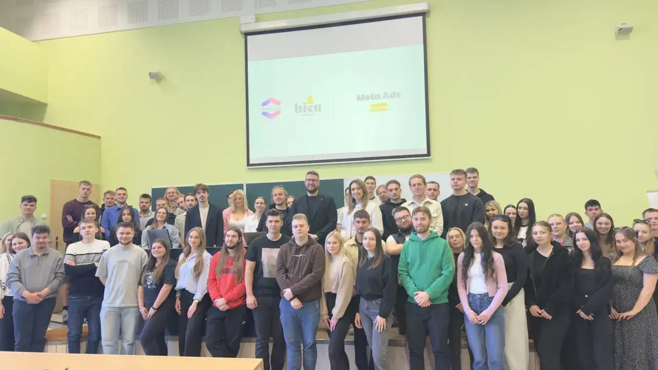 Grupa studentów na sali wykładowej, z logo