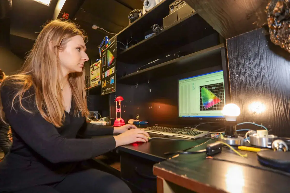 Studentka na elektrotechnika studia analizuje wykresy na monitorze.